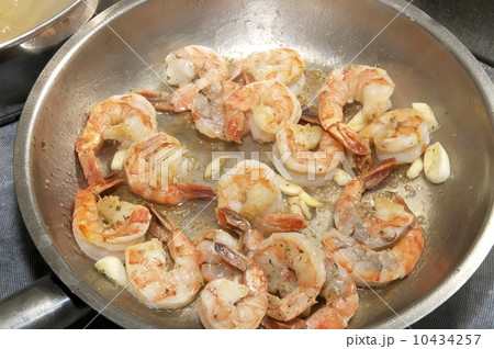 cooking shrimp in a pan in the kitchen at the restaurant 10434257