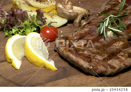 steak grilling on a wooden platter at restaurant steak grilling on a wooden platter at restaurant 10434258