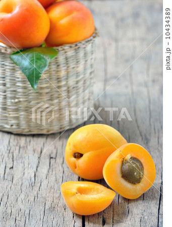 Apricots on the old wooden table and basket shoot in studio 10434389