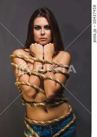 brunette hostage, captive woman bound with rope prisoner in jean 10437456