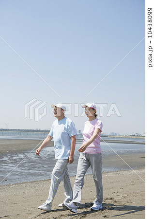 海辺でウォーキングをする60代の夫婦 10438099