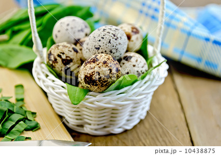 Eggs quail in basket with sorrel on board 10438875