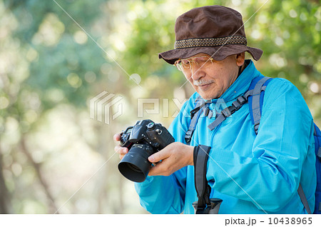 一眼レフカメラを持つシニア男性の写真素材