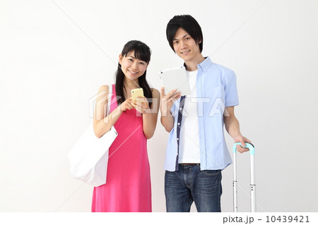 旅行中、スマホやタブレットで調べるカップル 10439421