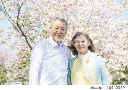 桜の前に立つシニア夫婦 10440369