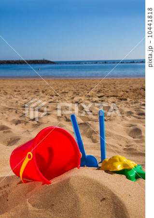 bucket with plastic beach toys in sand on sea shore 10441818