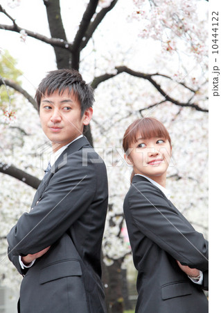 桜の前のスーツ姿の男女 10444122