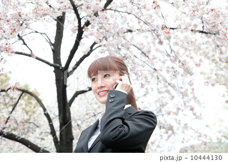 桜の前のスーツ姿の女性 10444130