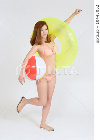 浮き輪を持つ水着の若い女性の写真素材