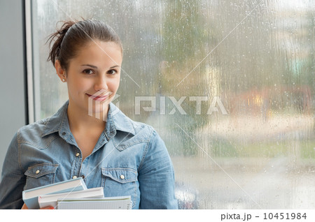 Student with books in front of window 10451984