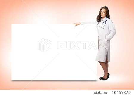 young woman doctor standing near a blank banner young woman doctor standing near a blank banner 10455829
