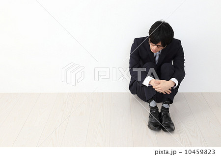 膝を抱えて座る男性社員の写真素材 [10459823] - PIXTA