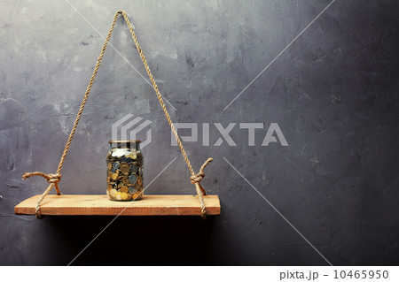 Glass jar with coins on the old wood shelf 10465950