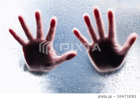 Silhouettes of two right hands behind wet glass 10471091