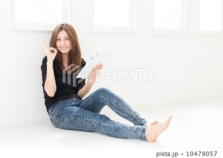 部屋でタブレットを見る女性 10479057