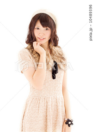 ラブリーなニットのワンピースを来て可愛らしいポーズをするキュートな日本の女の子の写真素材