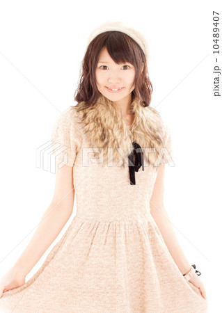 ラブリーなニットのワンピースを来て可愛らしいポーズをするキュートな日本の女の子 10489407
