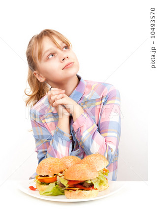 Little blond girl with big homemade hamburgers on white plate Little blond girl with big homemade hamburgers on white plate 10493570
