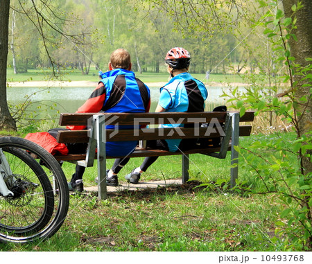 Mature couple sitting relaxing after cycling Mature couple sitting relaxing after cycling 10493768