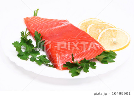Salmon steak with lemon slices and parsley on white plate Salmon steak with lemon slices and parsley on white plate 10499901