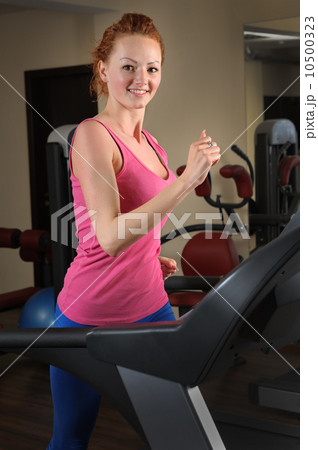 young man running at treadmill in gym 10500323