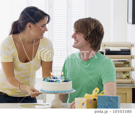 Woman bringing birthday cake to boyfriend 10503380