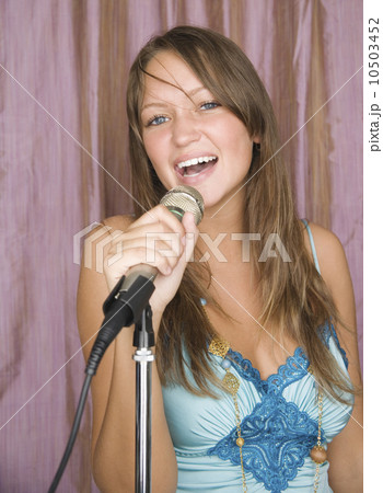 Young woman singing with microphone Young woman singing with microphone 10503452