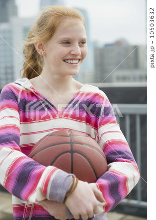 Portrait of girl (12-13) holding ball 10503632