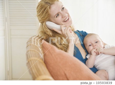 Mother holding baby and talking on the phone 10503839