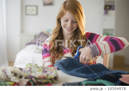 Girl (12-13) cutting clothing 10504078