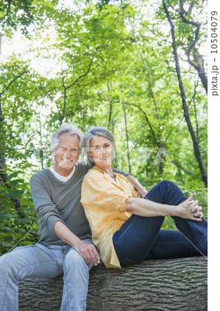 Senior couple sitting on log in forest Senior couple sitting on log in forest 10504079