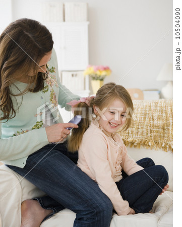 Mother brushing daughter's hair Mother brushing daughter's hair 10504090
