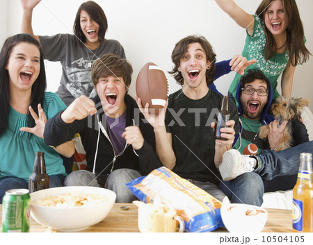 Group of friends cheering on sofa Group of friends cheering on sofa 10504105