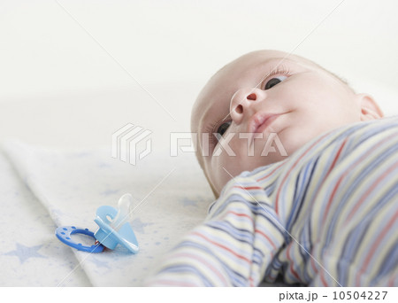 Close up of baby lying down next to pacifier 10504227