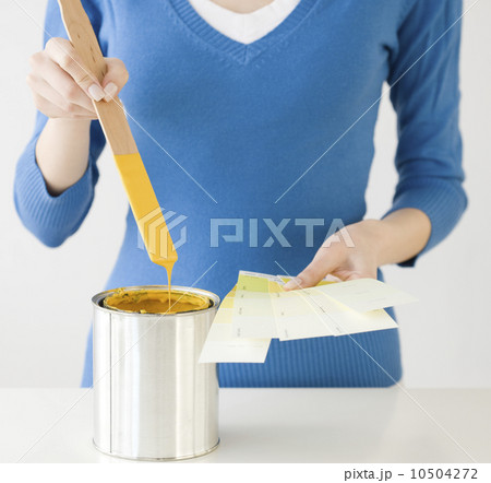 Woman holding paint swatches next to paint can 10504272