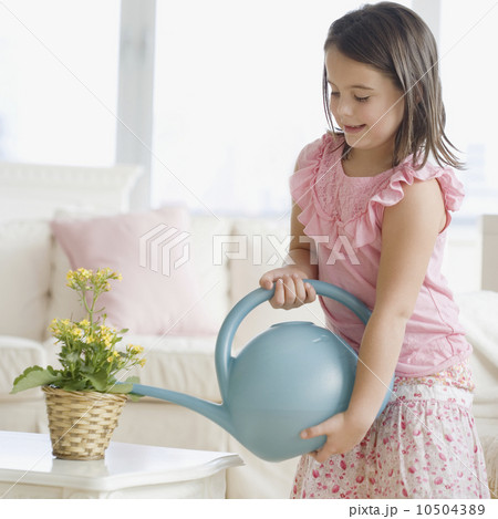 Girl watering plant indoors 10504389