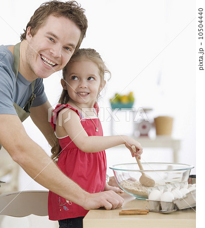 Father and daughter mixing batter in kitchen Father and daughter mixing batter in kitchen 10504440