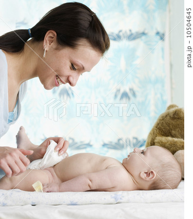 Mother changing baby’s diaper 10504645