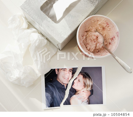 Ripped photograph next to ice cream and tissues Ripped photograph next to ice cream and tissues 10504854