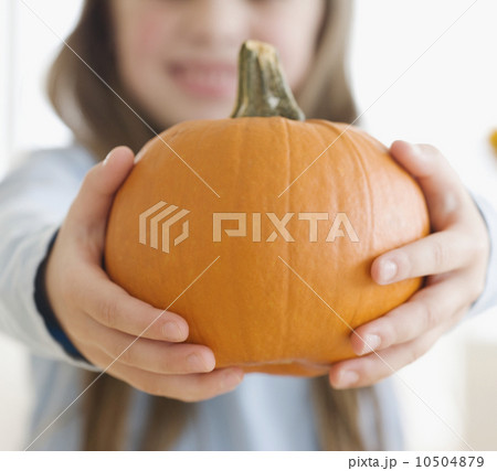 Close up of girl holding pumpkin Close up of girl holding pumpkin 10504879
