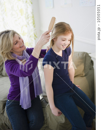 USA, Jersey City, New Jersey, mother brushing daughter's (10-11) hair 10505051