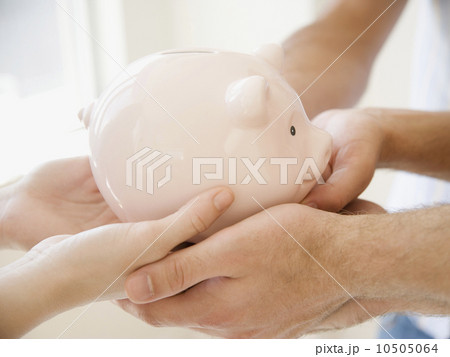 Three people holding piggy bank 10505064