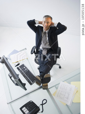 Businessman with feet on desk smiling Businessman with feet on desk smiling 10505138