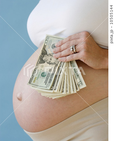 Pregnant woman holding stack of money Pregnant woman holding stack of money 10505144