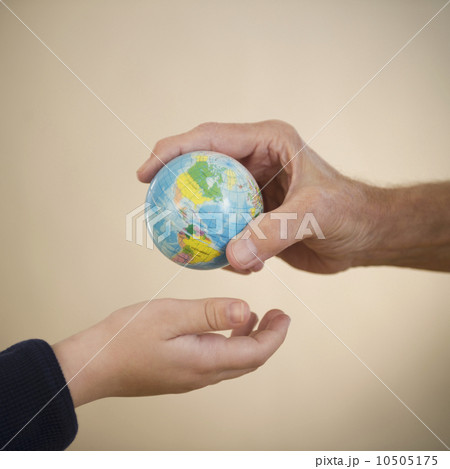 Close up of hands of grandfather and grandson (8-9) with small globe 10505175