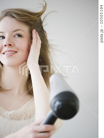 Woman blow drying hair Woman blow drying hair 10505194