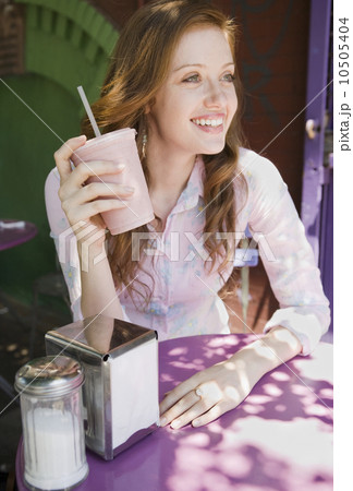 Woman drinking smoothie in outdoor cafe Woman drinking smoothie in outdoor cafe 10505404