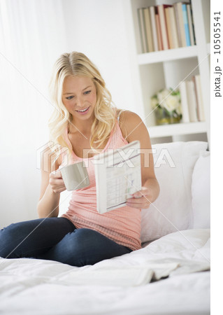 Young woman reading newspaper in bedroom 10505541