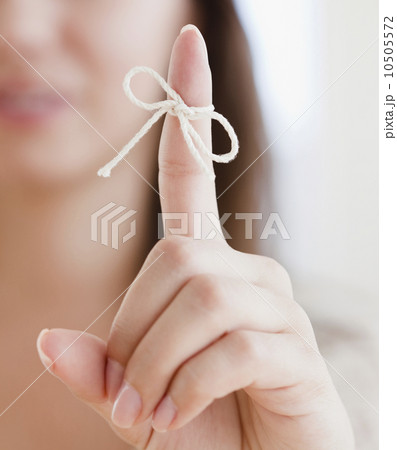 Close up of woman's finger with tied knot Close up of woman's finger with tied knot 10505572