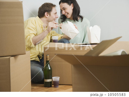 Couple eating take out on boxes in new house Couple eating take out on boxes in new house 10505583